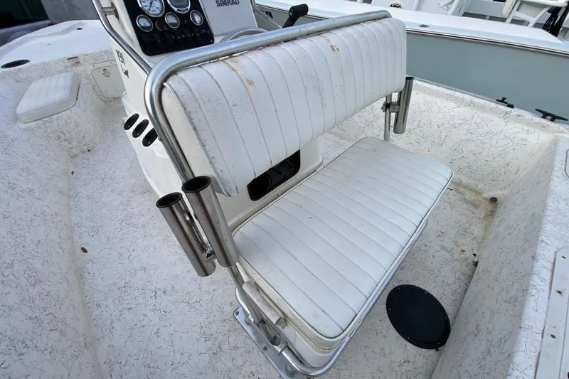 Slide: The Image of 2006 Mako 191 Inshore boat interior with white cushioned seating and rod holders. - 51