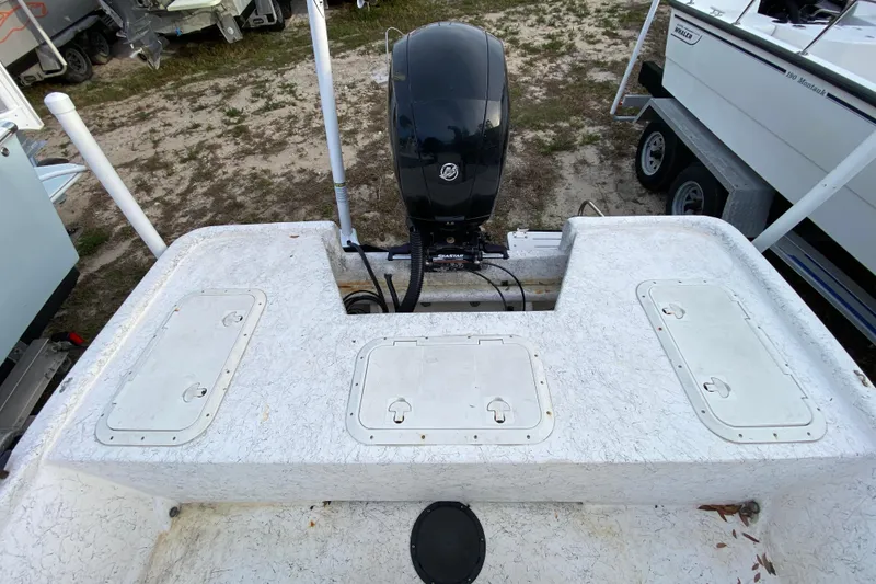 Slide: The Image of 2006 Mako 191 Inshore boat with outboard motor and storage compartments. - 52