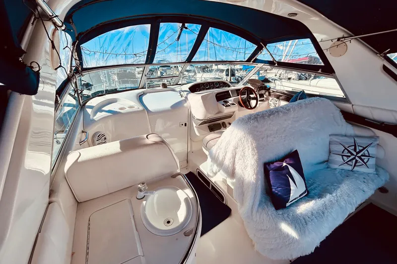 Slide: The Image of 1999 Sea Ray Sundancer 330 interior with plush seating and nautical decor. - 10