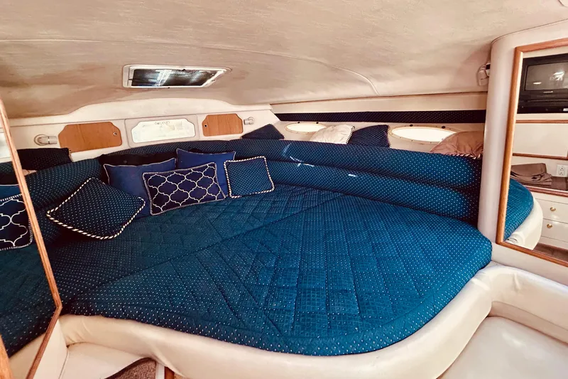 Slide: The Image of Interior cabin of 1999 Sea Ray Sundancer 330 with blue bedding and pillows. - 14