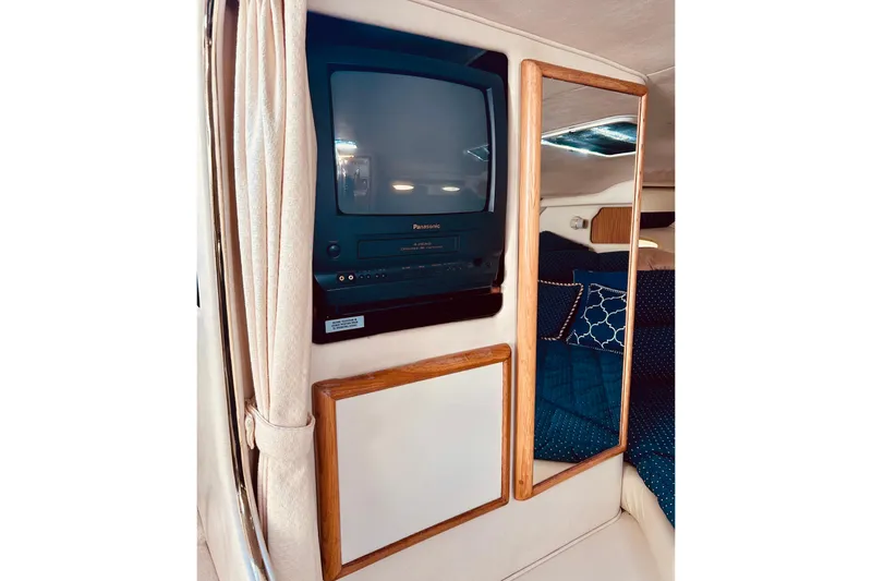 Slide: The Image of 1999 Sea Ray Sundancer 330 interior with vintage TV and cozy seating area. - 15