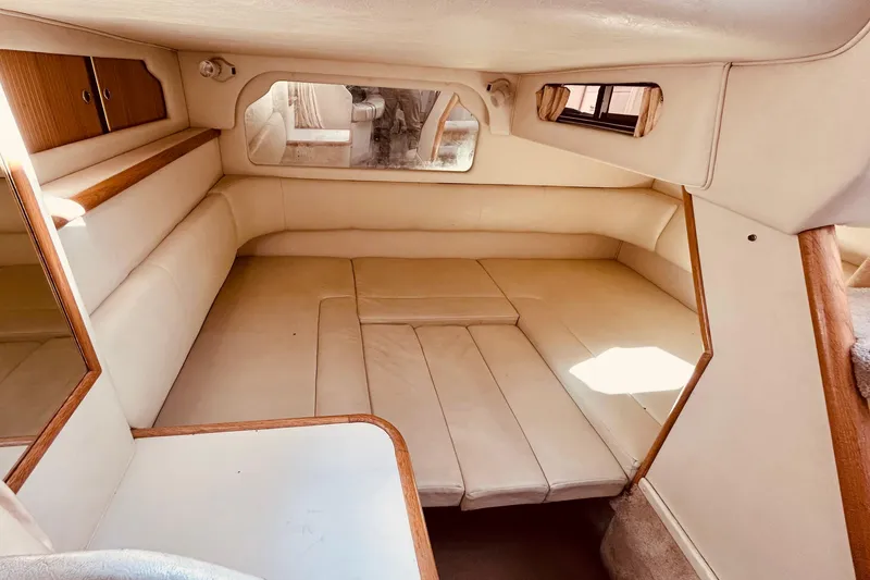 Slide: The Image of 1999 Sea Ray Sundancer 330 cabin interior with beige seating and wood accents. - 16