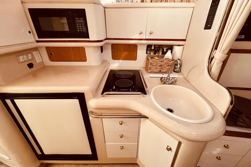 Slide: The Image of 1999 Sea Ray Sundancer 330 galley with sink, stove, microwave, and storage cabinets. - 18