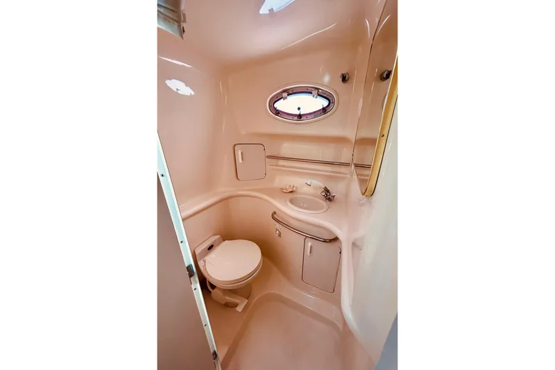 Slide: The Image of 1999 Sea Ray Sundancer 330 bathroom with toilet, sink, and porthole window. - 19