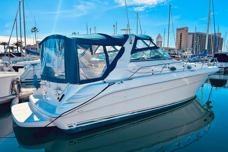 Slide: The Image of 1999 Sea Ray Sundancer 330 yacht docked in a marina under a clear blue sky. - 2