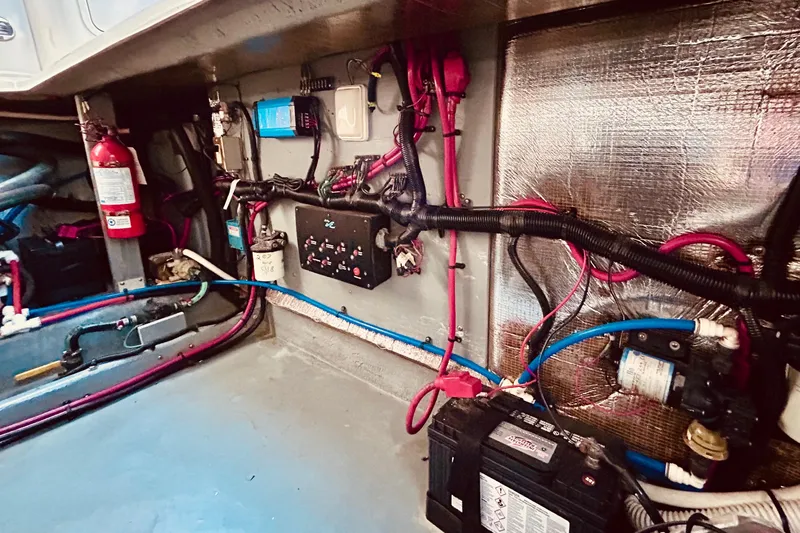 Slide: The Image of Engine room of 1999 Sea Ray Sundancer 330 with wiring, battery, and fire extinguisher. - 21