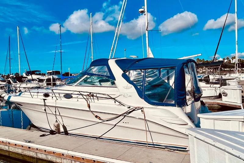 Slide: The Image of 1999 Sea Ray Sundancer 330 docked at marina under clear blue sky. - 4