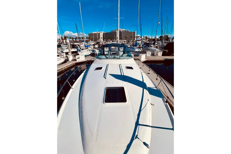 Slide: The Image of 1999 Sea Ray Sundancer 330 docked at marina, clear blue sky, surrounded by boats. - 6