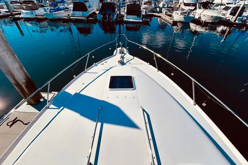 Slide: The Image of 1999 Sea Ray Sundancer 330 docked at marina, surrounded by boats and calm water. - 7