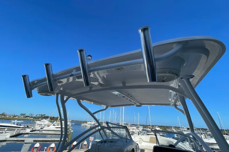 Slide: The Image of 2017 Edgewater 248CX Crossover boat with rod holders, docked at a marina under clear blue skies. - 11
