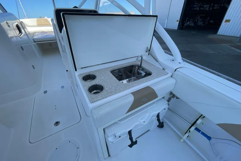 Slide: The Image of 2017 Edgewater 248CX Crossover boat interior with sink and cup holders. - 14