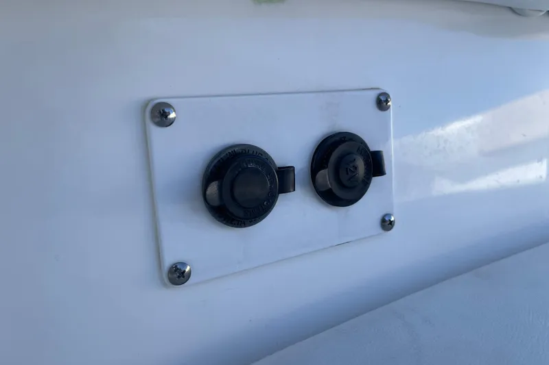 Slide: The Image of Close-up of 2017 Edgewater 248CX Crossover boat's dual 12V power outlets. - 17