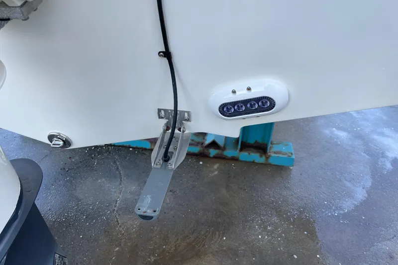 Slide: The Image of 2017 Edgewater 248CX Crossover boat detail showing underwater light and trim tab. - 20