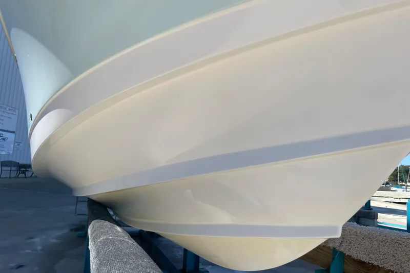 Slide: The Image of 2017 Edgewater 248CX Crossover boat hull on display in a marina setting. - 21