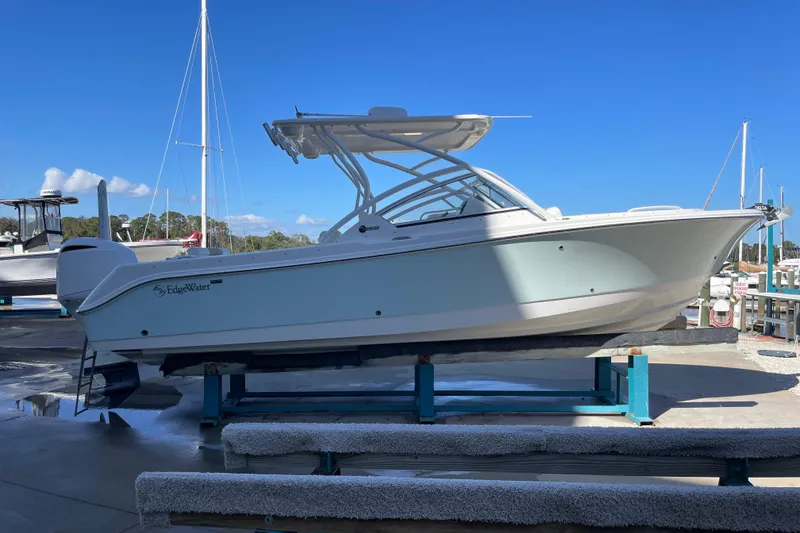 Slide: The Image of 2017 Edgewater 248CX Crossover boat on display at a marina under clear blue skies. - 3