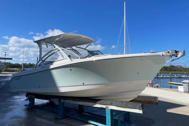 Slide: The Image of 2017 Edgewater 248CX Crossover boat on dock under clear blue sky. - 4