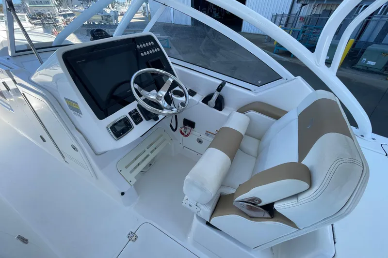 Slide: The Image of 2017 Edgewater 248CX Crossover boat cockpit with steering wheel and control panel. - 5