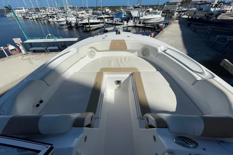 Slide: The Image of 2017 Edgewater 248CX Crossover boat interior at marina, showcasing spacious seating and sleek design. - 8