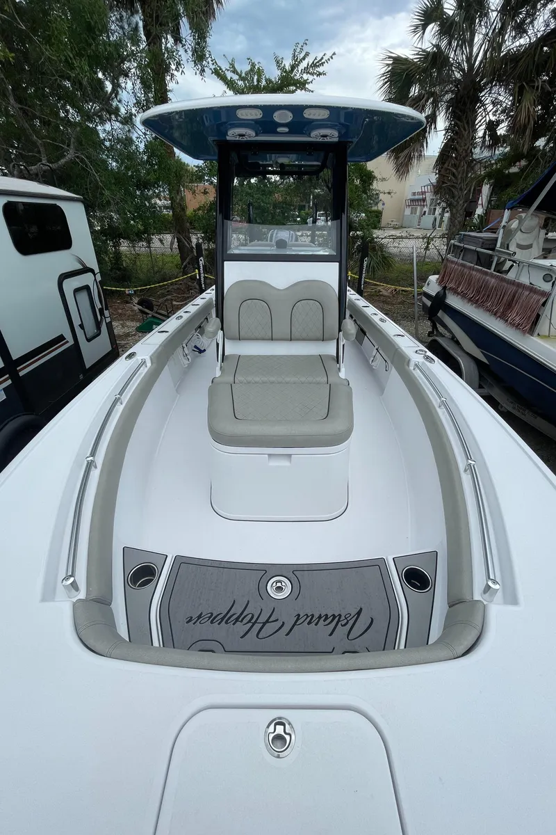 Slide: The Image of 2022 Sportsman Masters 247OE Bay Boat with seating and console, docked outdoors. - 12
