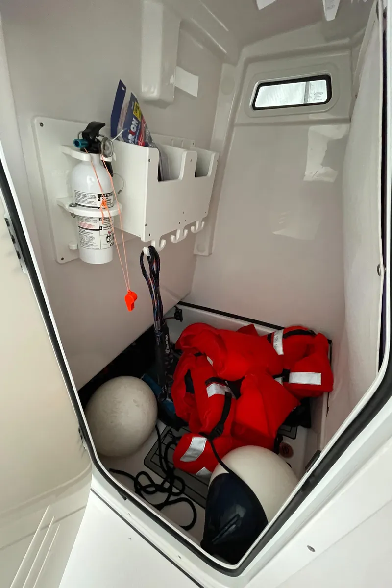 Slide: The Image of Storage compartment in 2022 Sportsman Masters 247OE Bay Boat with safety gear and equipment. - 18
