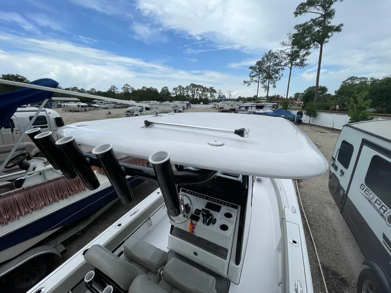 Slide: The Image of 2022 Sportsman Masters 247OE Bay Boat with T-top and rod holders in a marina. - 23