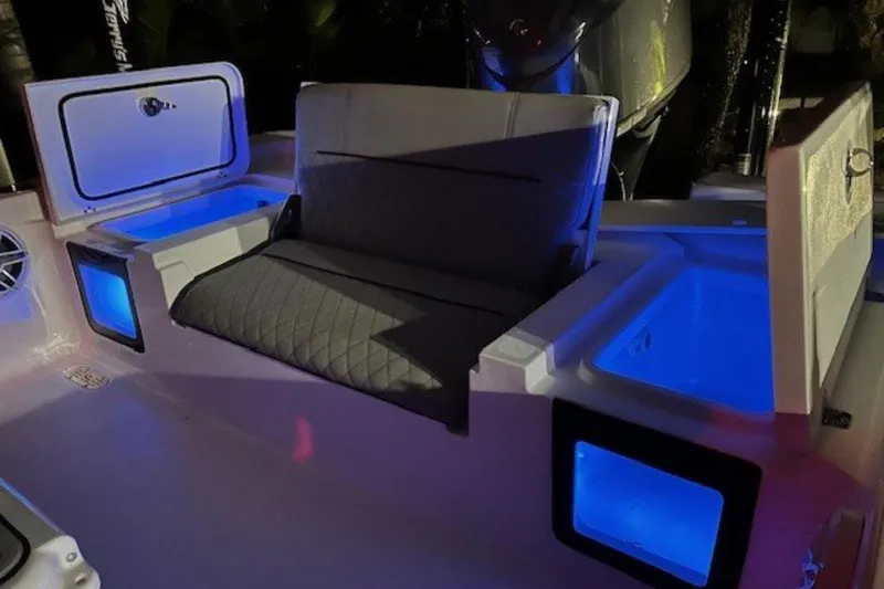 Slide: The Image of 2022 Sportsman Masters 247OE Bay Boat interior with illuminated storage compartments and seating. - 26
