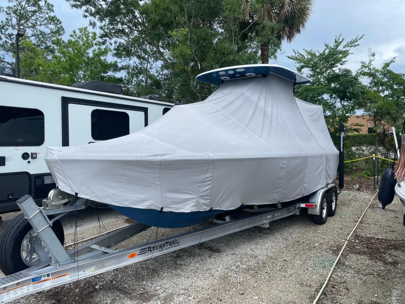 Slide: The Image of 2022 Sportsman Masters 247OE Bay Boat covered on trailer, parked outdoors. - 28