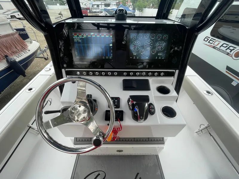 Slide: The Image of 2022 Sportsman Masters 247OE Bay Boat dashboard with steering wheel and dual displays. - 4
