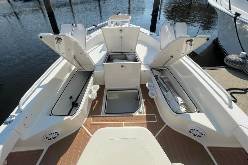 Slide: The Image of 2021 Pathfinder 2600 TRS boat with open storage compartments at dockside. - 10