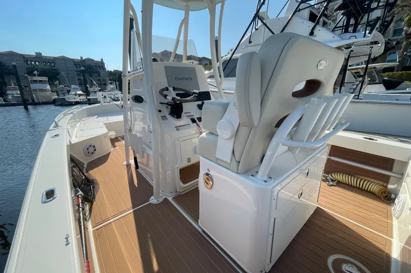 Slide: The Image of 2021 Pathfinder 2600 TRS boat interior with helm, seating, and fishing rod holders. - 12