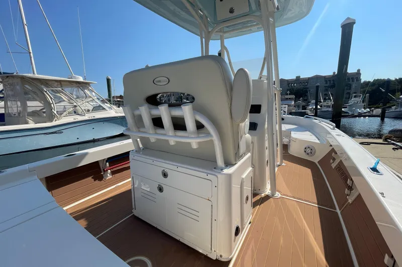 Slide: The Image of 2021 Pathfinder 2600 TRS boat interior with seating and rod holders at a marina. - 15