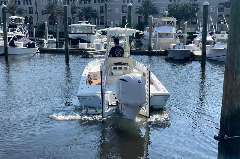 Slide: The Image of 2021 Pathfinder 2600 TRS boat navigating marina with docked yachts in background. - 2