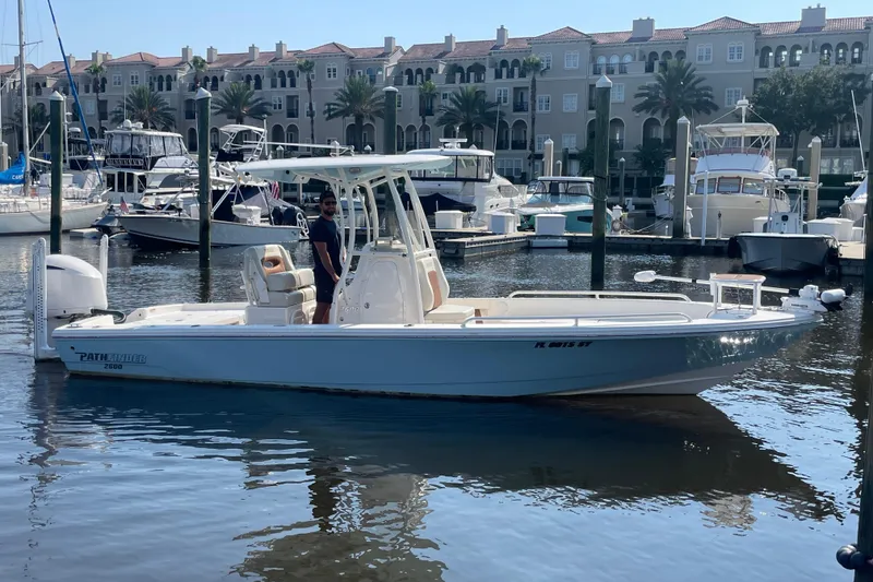 Slide: The Image of 2021 Pathfinder 2600 TRS boat docked in a marina with luxury yachts. - 5