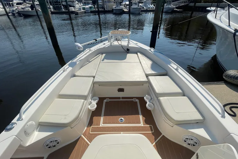 Slide: The Image of 2021 Pathfinder 2600 TRS boat interior with cushioned seating at marina. - 8