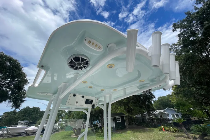 Slide: The Image of 2021 Sea Pro 219 Center Console boat with rod holders and speaker, under a blue sky. - 12