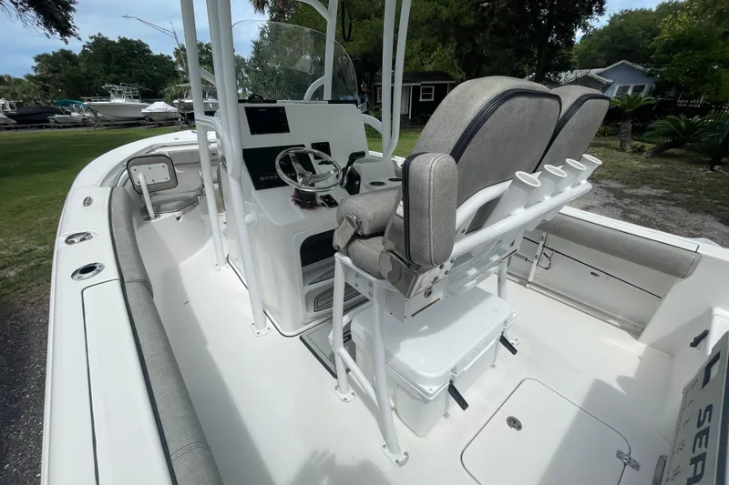Slide: The Image of 2021 Sea Pro 219 Center Console boat interior with helm, seating, and rod holders. - 13