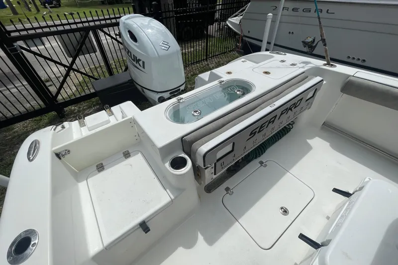 Slide: The Image of 2021 Sea Pro 219 Center Console boat with Suzuki outboard motor, docked near a fence. - 15