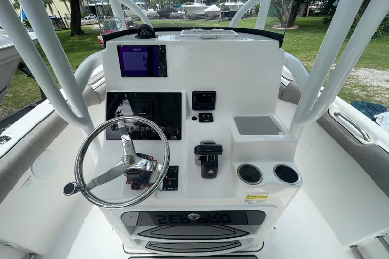 Slide: The Image of 2021 Sea Pro 219 Center Console boat dashboard with steering wheel and navigation controls. - 17