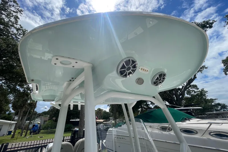 Slide: The Image of 2021 Sea Pro 219 Center Console boat with speakers and canopy under bright sky. - 9