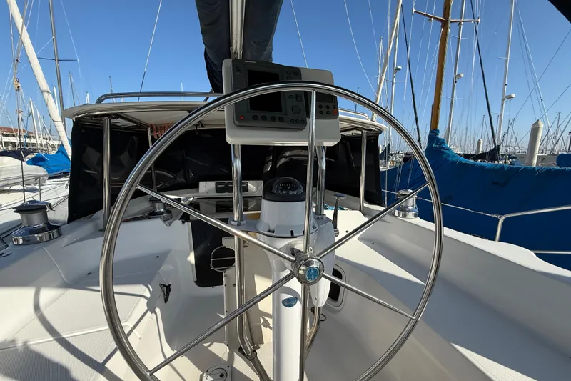 Slide: The Image of Steering wheel of 1999 Hunter Passage 420 sailboat in marina setting. - 17