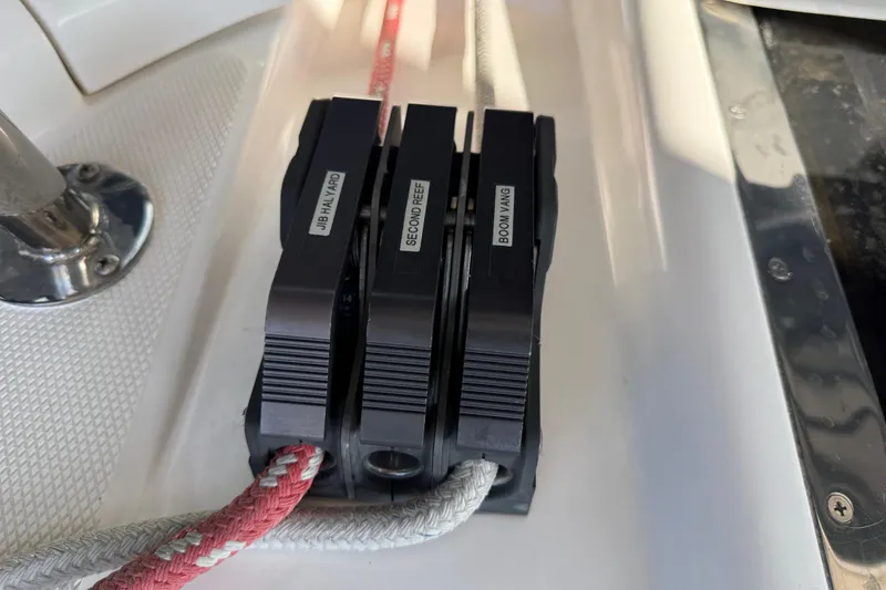 Slide: The Image of Rope clutches on 1999 Hunter Passage 420 sailboat deck, labeled for jib halyard, second reef, boom vang. - 20