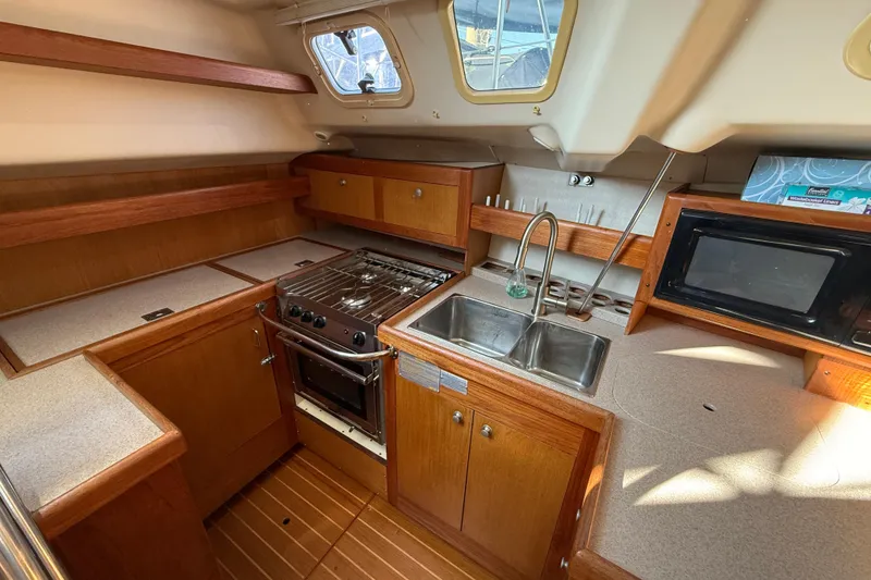 Slide: The Image of 1999 Hunter Passage 420 yacht kitchen with stove, sink, and microwave. - 22