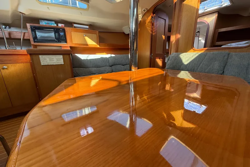 Slide: The Image of Interior of 1999 Hunter Passage 420 yacht with polished wood table and cozy seating. - 25
