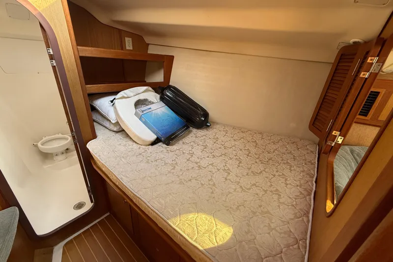 Slide: The Image of 1999 Hunter Passage 420 cabin interior with bed, storage, and adjacent bathroom. - 27