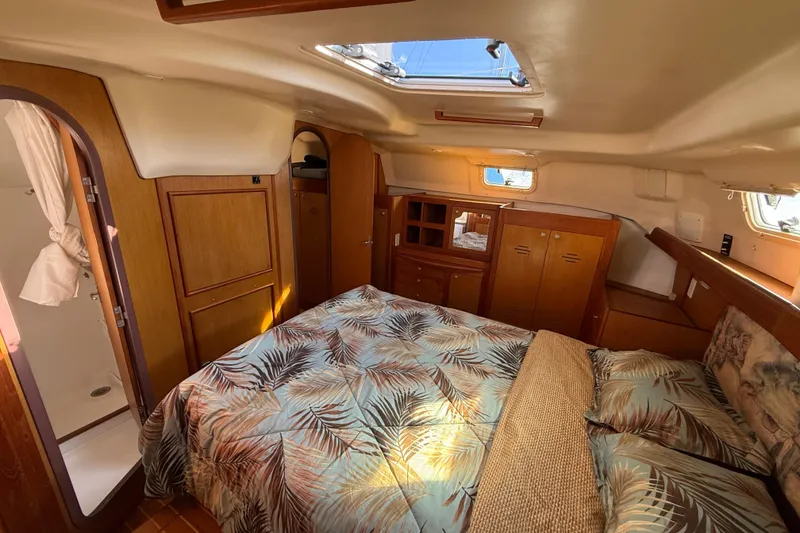 Slide: The Image of 1999 Hunter Passage 420 yacht interior with cozy bedroom, wooden cabinets, and skylight. - 32