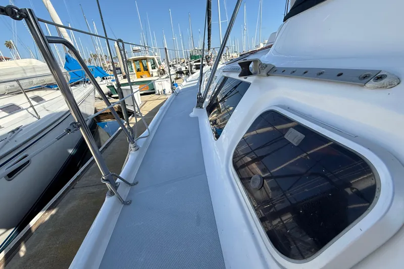 Slide: The Image of 1999 Hunter Passage 420 sailboat deck view at marina, showcasing sleek design and windows. - 7