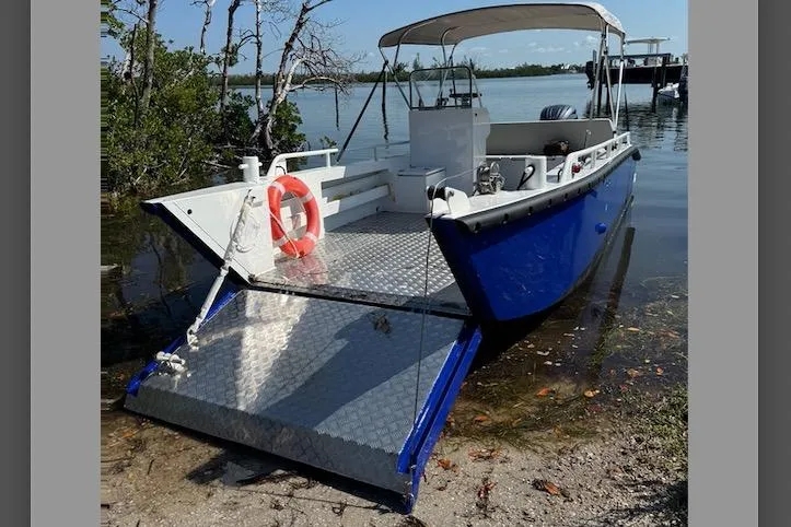 Slide: The Image of 2026 Gospel Boat Landing Craft with open ramp, docked by a serene lakeside. - 9