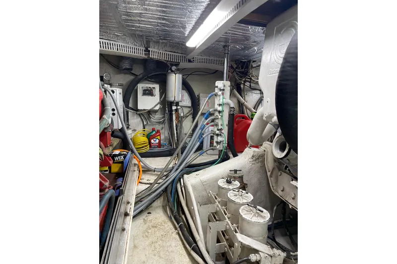 Slide: The Image of Engine room of 1988 Cheoy Lee 58 Convertible yacht with equipment and cables. - 11