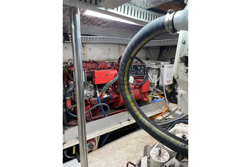 Slide: The Image of Engine room of 1988 Cheoy Lee 58 Convertible yacht, featuring red machinery and hoses. - 12