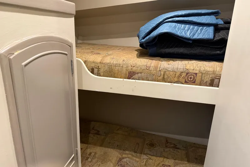 Slide: The Image of Interior of 1988 Cheoy Lee 58 Convertible with bunk beds and folded blankets. - 33